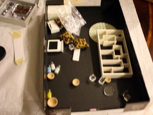 disorganized box of dollhouse miniatures