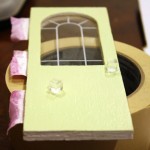 Gluing door knobs to the Coventry Cottage dollhouse